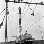 166469 Afbeelding van werkzaamheden aan de bovenleiding van het spoor te Lunetten bij Utrecht, met behulp van een rolladder.